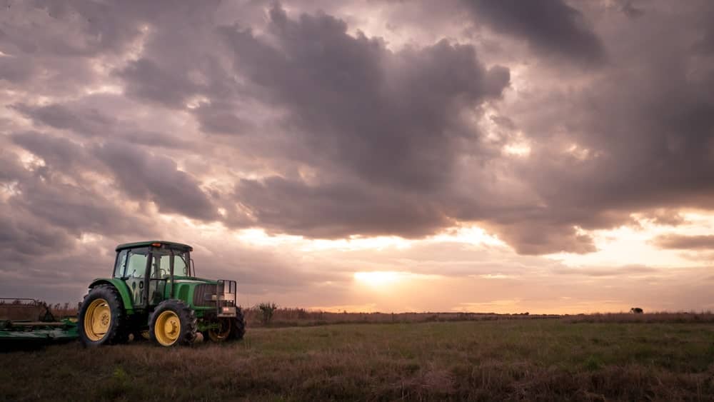 Tractor on field with sunset skies