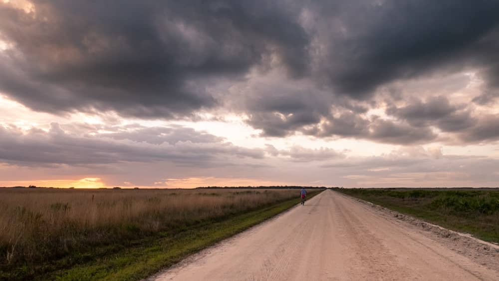 dirt road and cloudy skies at sunset