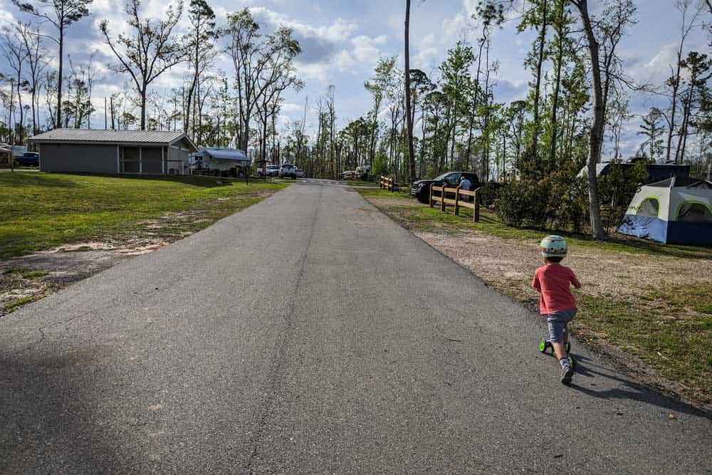 boy riding scooter on campground road