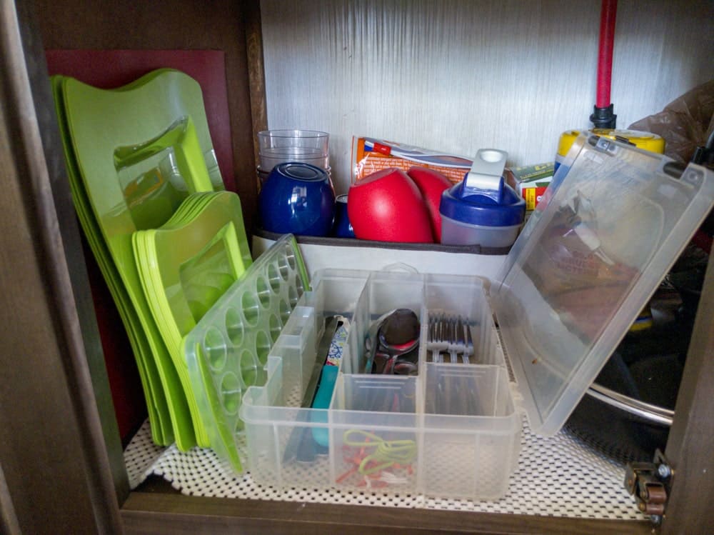 cabinet with stacked dishes, flatware and cups