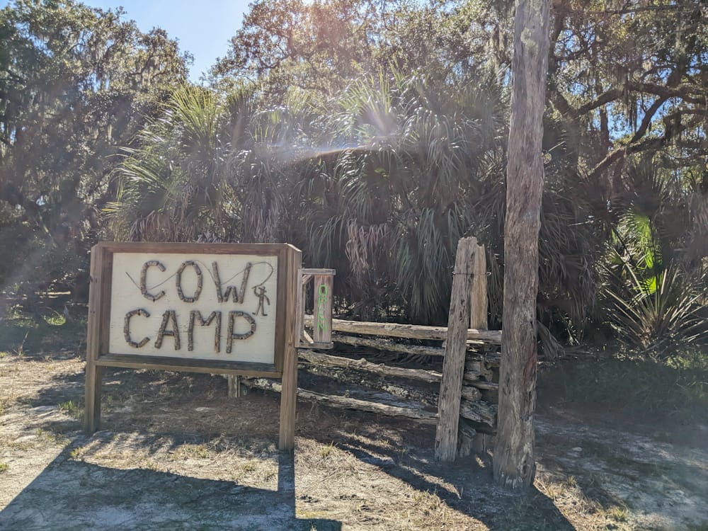 sign made  of wood with the words "cow camp"