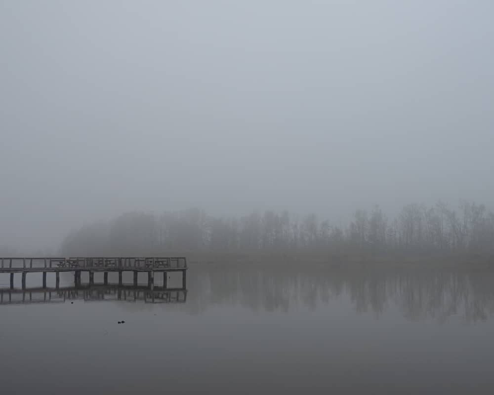 Foggy morning over pier and lake