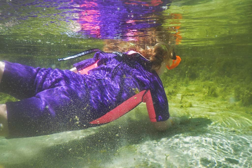 Girl snorkeling in shallow water.
