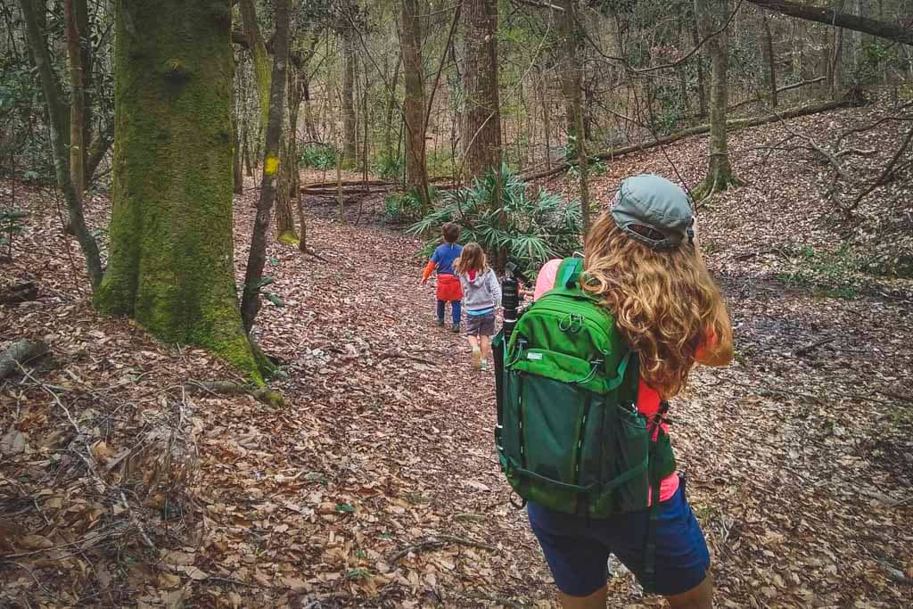 woman wearing Mindshift Backlight 18L taking photo of kids on nature trail