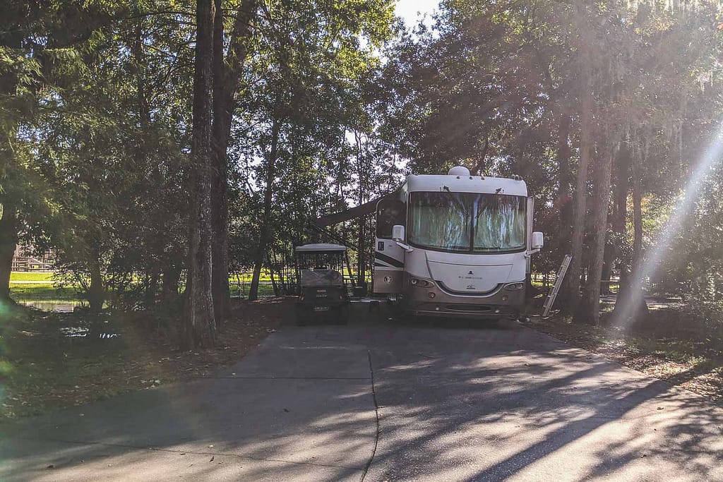 A motorhome and golf cart in premium campsite at Disney's Fort Wilderness