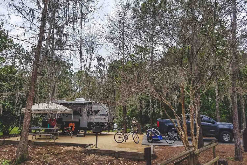 A tent site with a small travel trailer and truck at Disney's Fort Wilderness campground