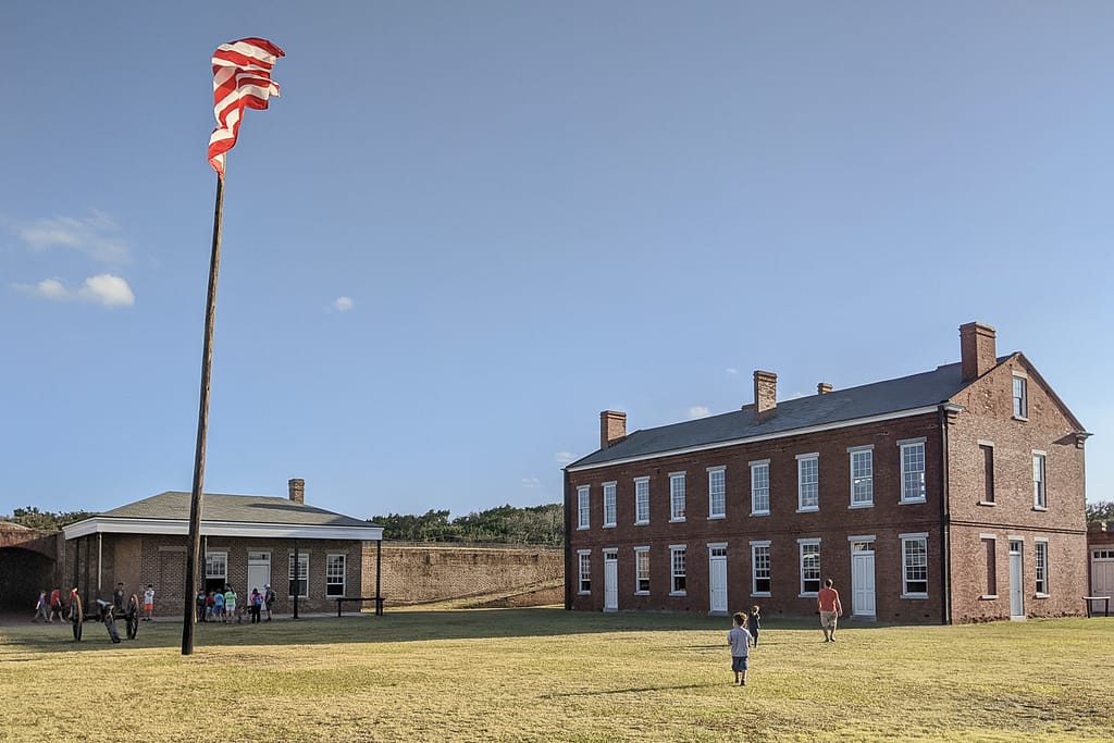 Post flag and one of the two story buildings inside Fort Clinch