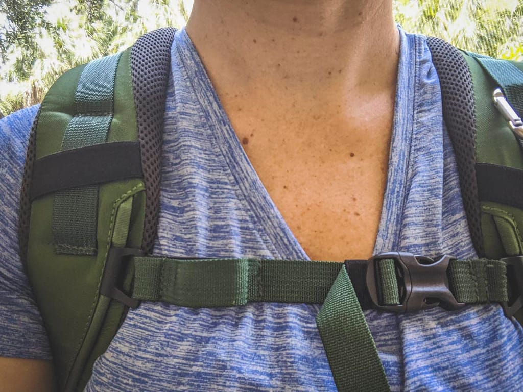Woman showing backpack straps fit around neck area