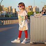 Girl standing on the street next to suitcase
