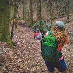 woman wearing Mindshift Backlight 18L taking photo of kids on nature trail