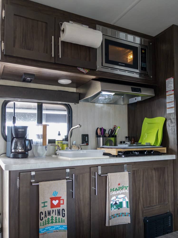 camper kitchen showing stove, microwave, sink