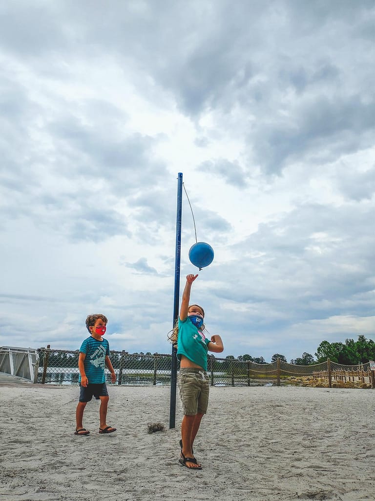 girl and boy playing tetherball at the beach at Disney's fort wilderness