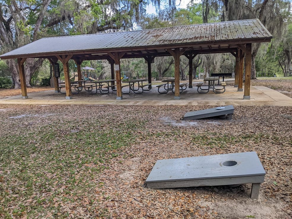 Two corn hole bases in front of large pavilion at Lake Griffin State Park