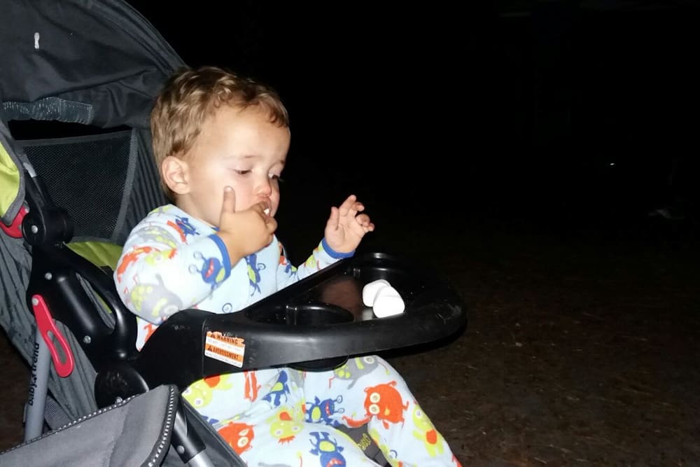 toddler eating marshmallows on stroller with tray