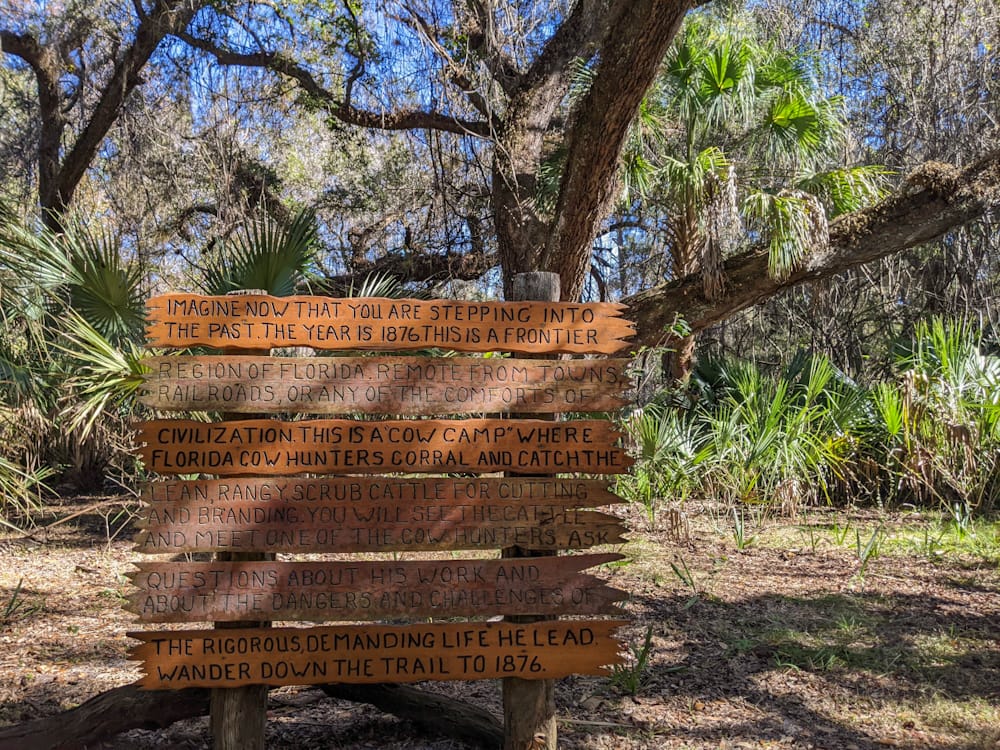 wooden sign with multiple planks explaining the brief history of the area